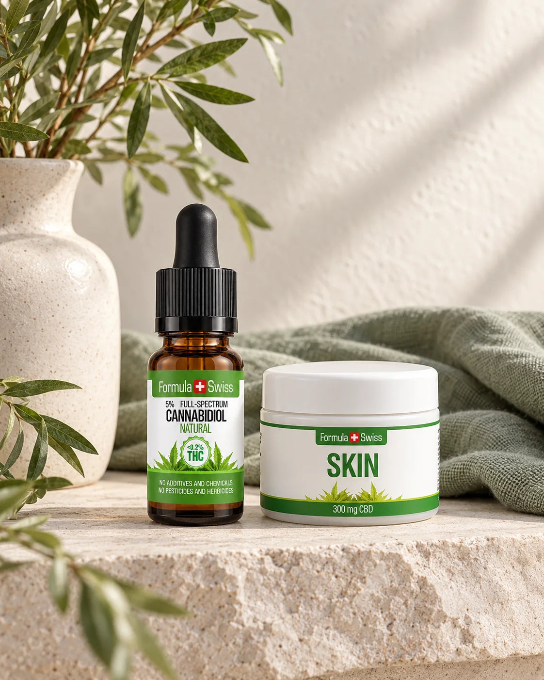 Formula Swiss CBD oil and Skin Balm arranged on pale stone with sage linen